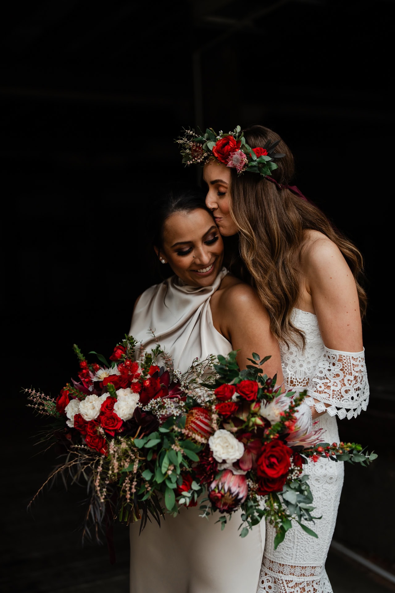 bride hugging bride and kissing on head