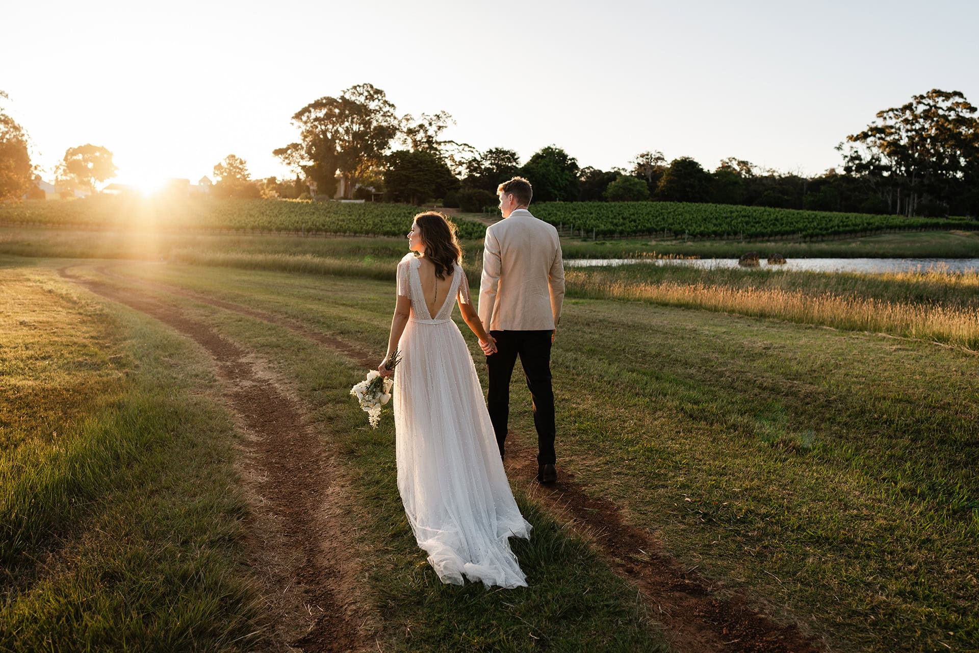 bride and groom walking at sunset