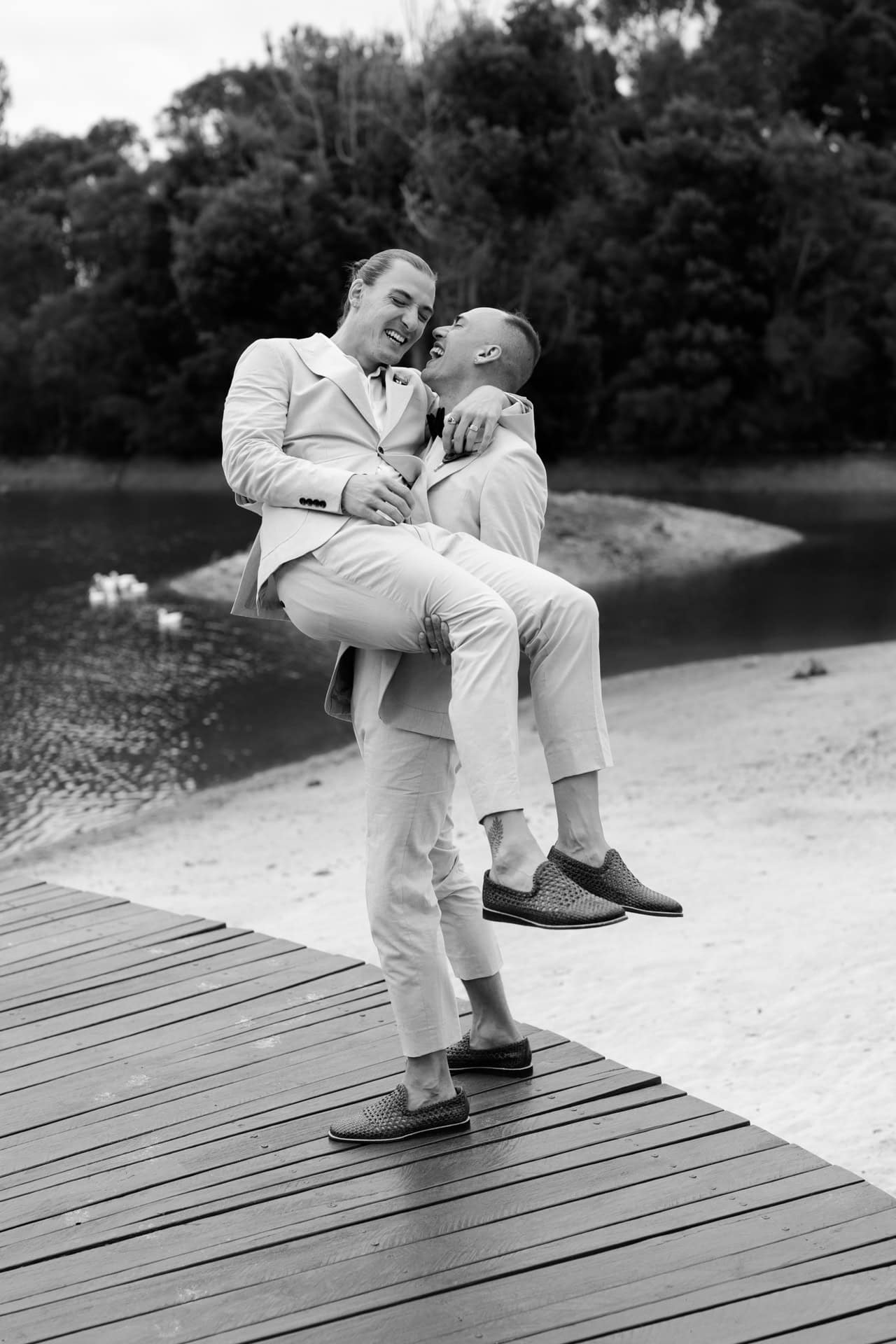 Perth wedding photographer groom wearing cream coloured suit picking up groom and laughing at Perth wedding