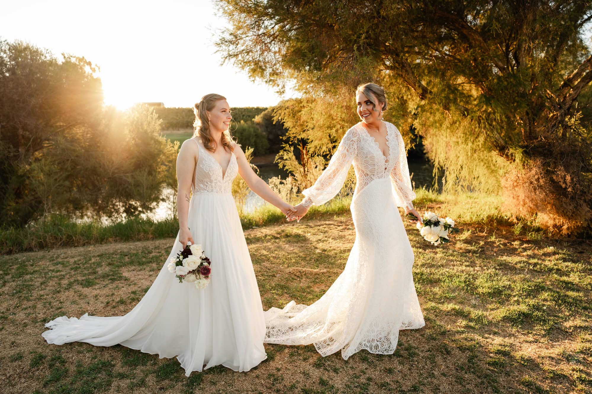 wedding photos perth two brides wearing white dresses holding hands walking at sunset