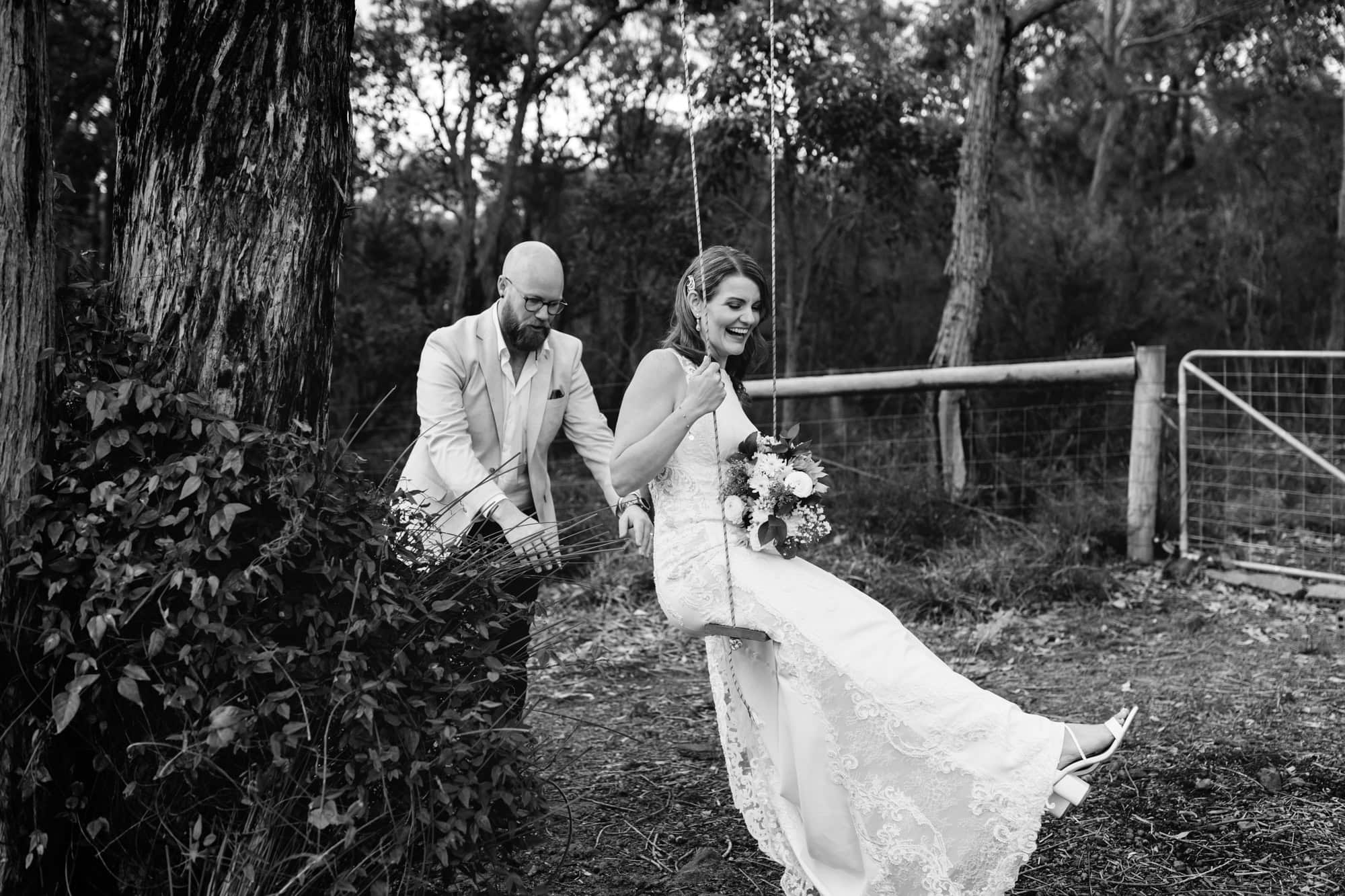 wedding photos Perth groom pushing bride on swing next to tree