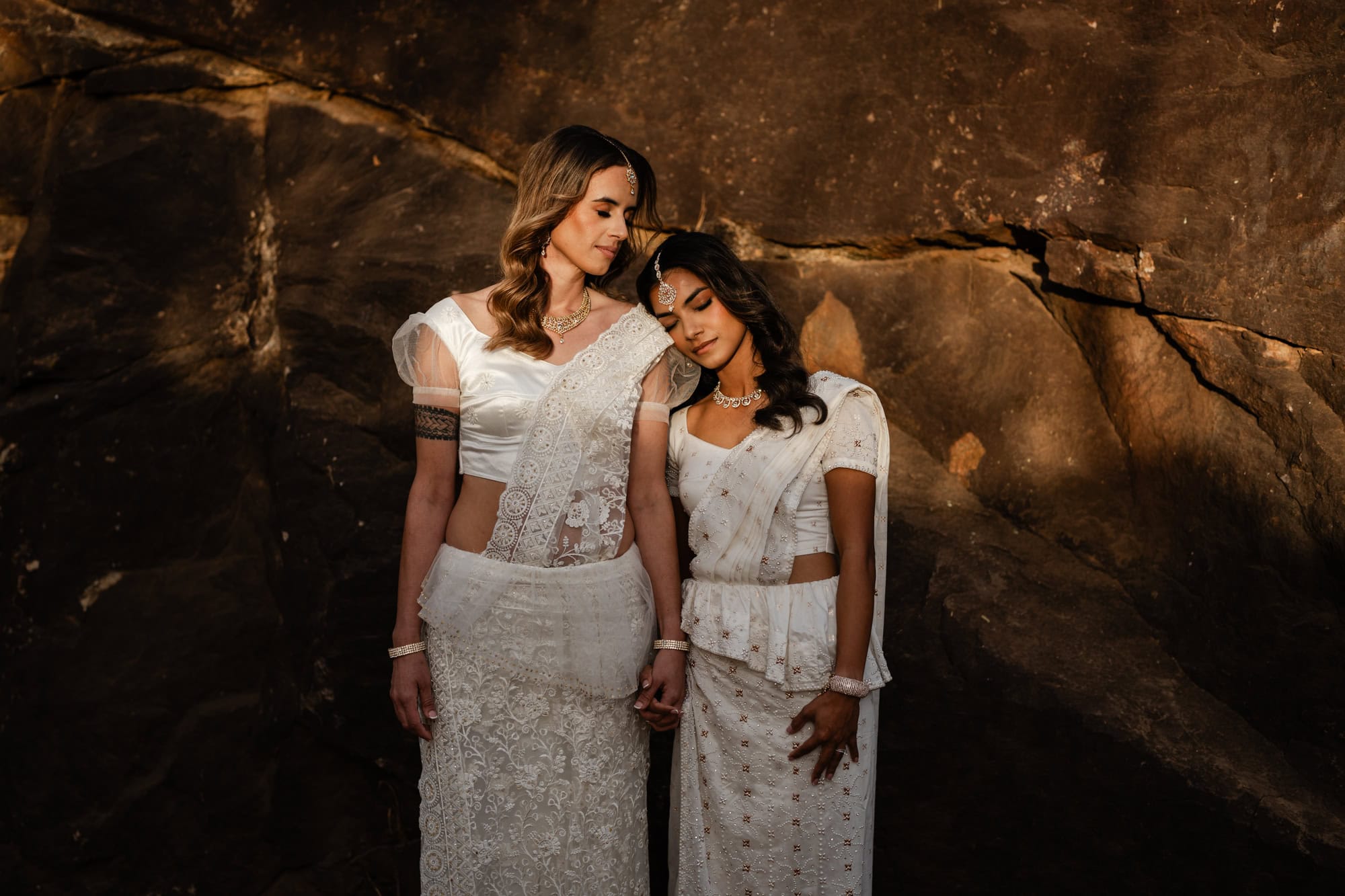 wedding photos Perth two brides wearing sarees with heads on each other's shoulders at sunset