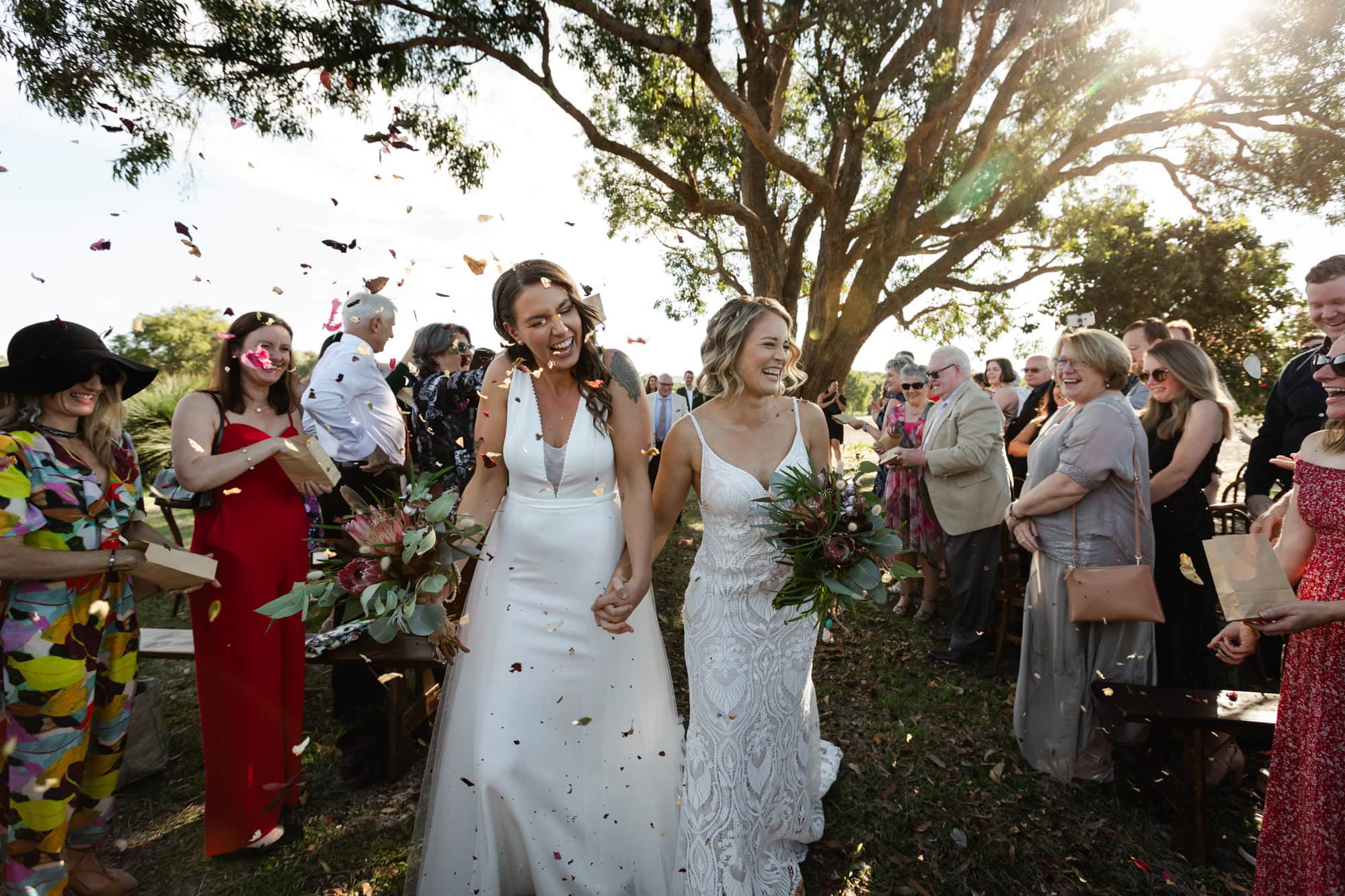 wedding photos Perth two brides walking down ceremony aisle with confetti flying