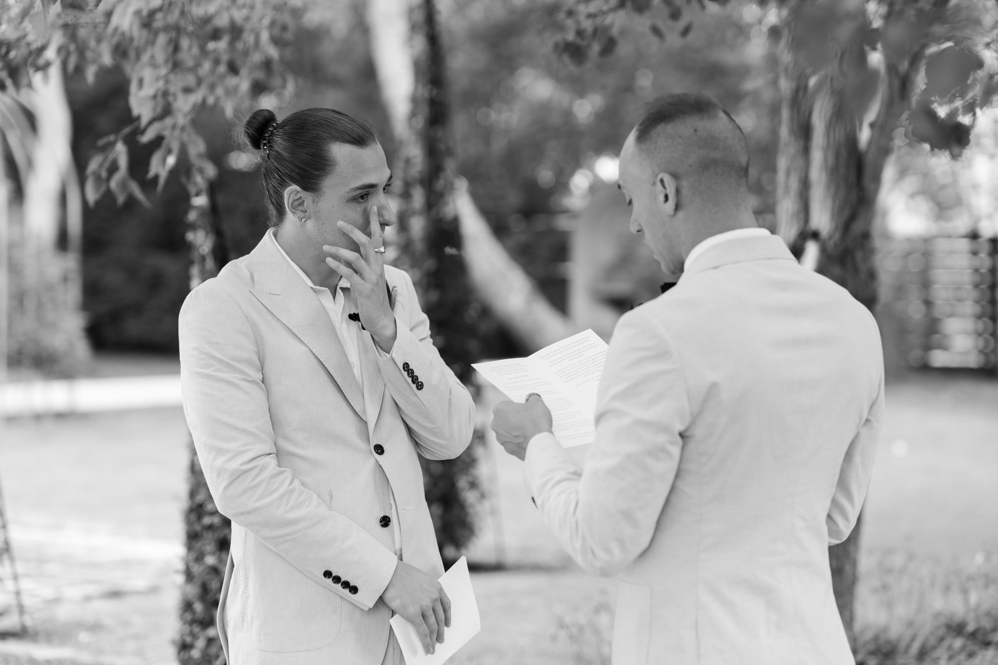 groom wearing cream suit crying at wedding ceremony be read vows by groom