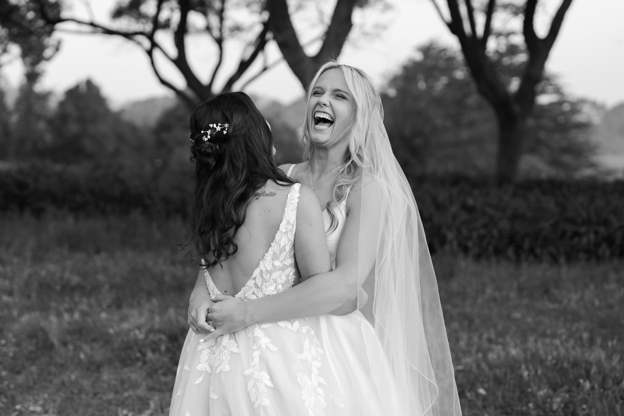 wedding photos Perth two brides wearing white dresses hugging laughing