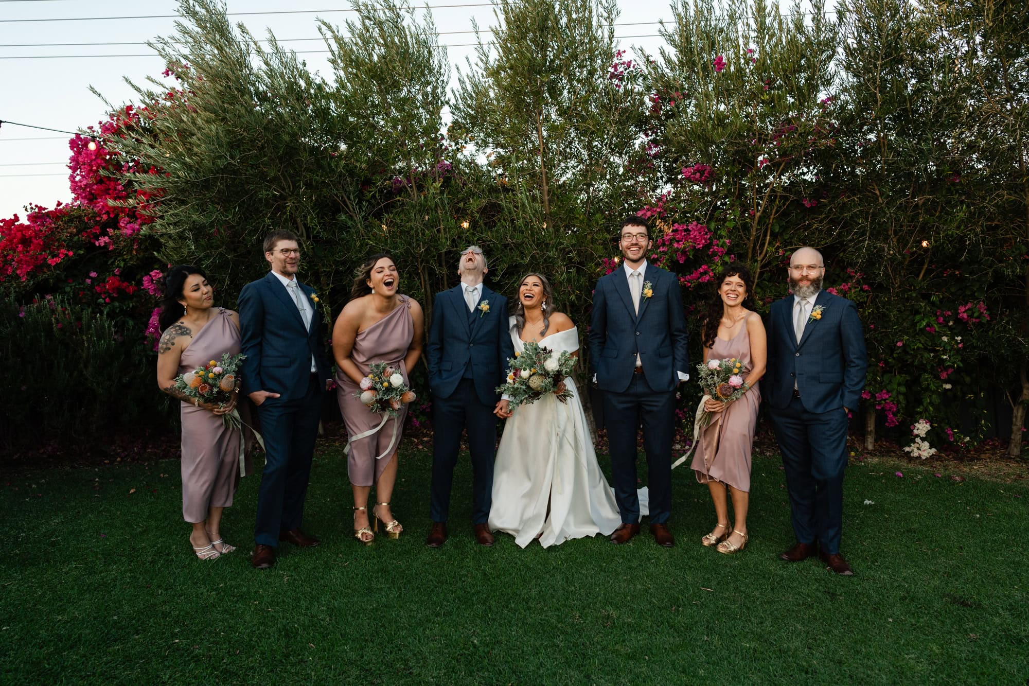 wedding photos Perth wedding party wearing blue suits and purple dresses standing in line laughing