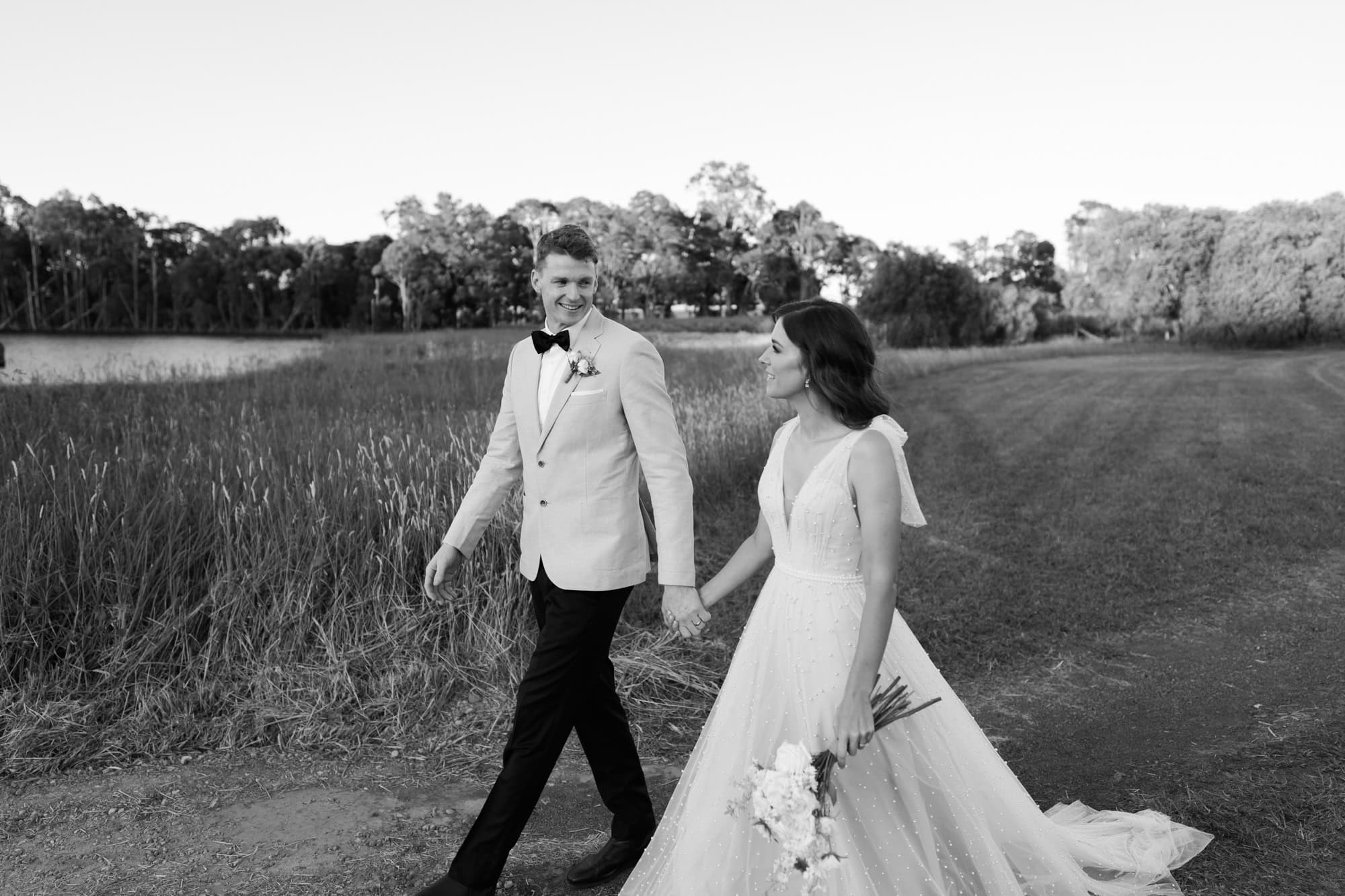 wedding photos Perth groom and bride holding hands walking in field