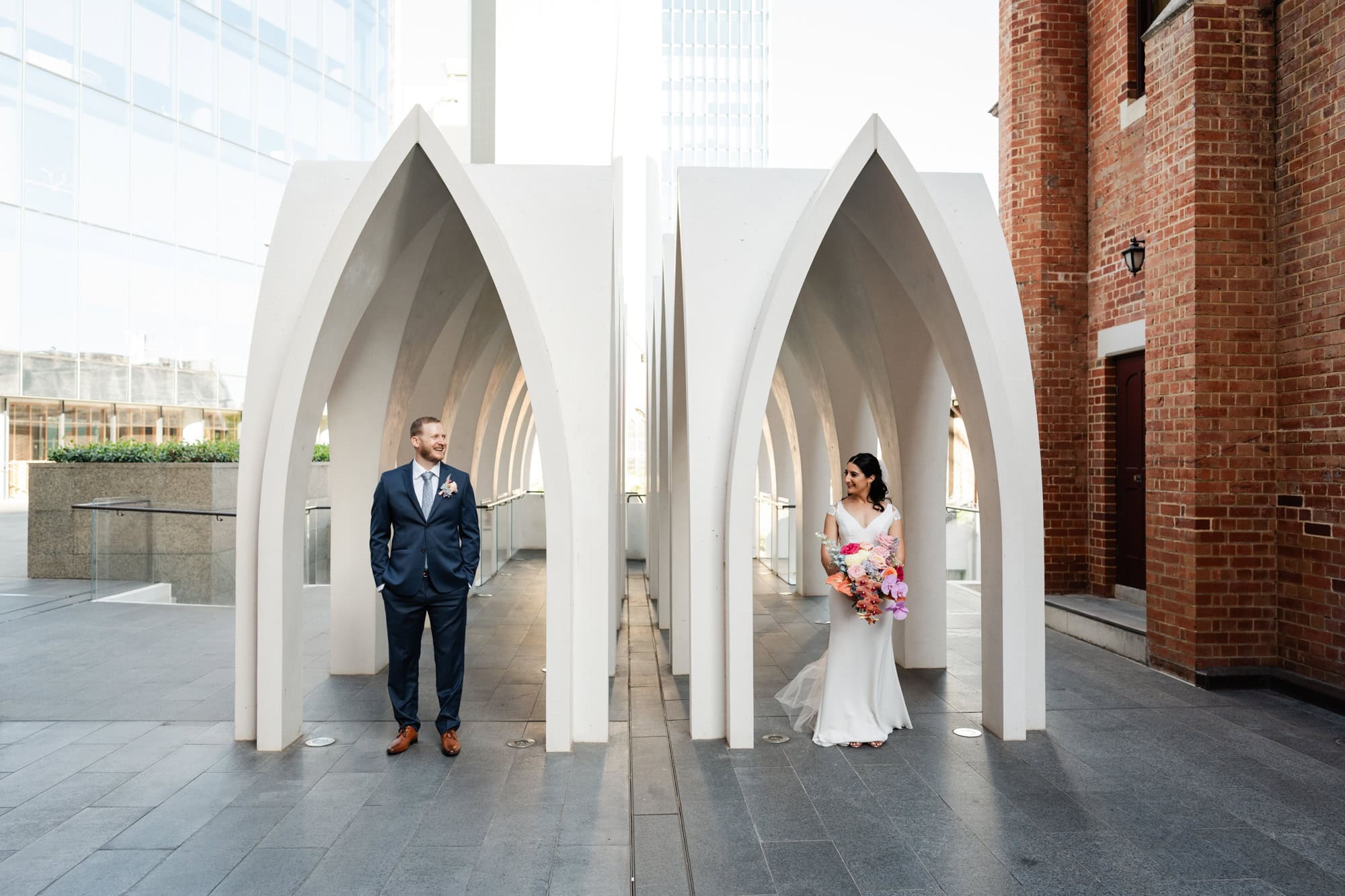 wedding photos Perth groom and bride standing under white arches