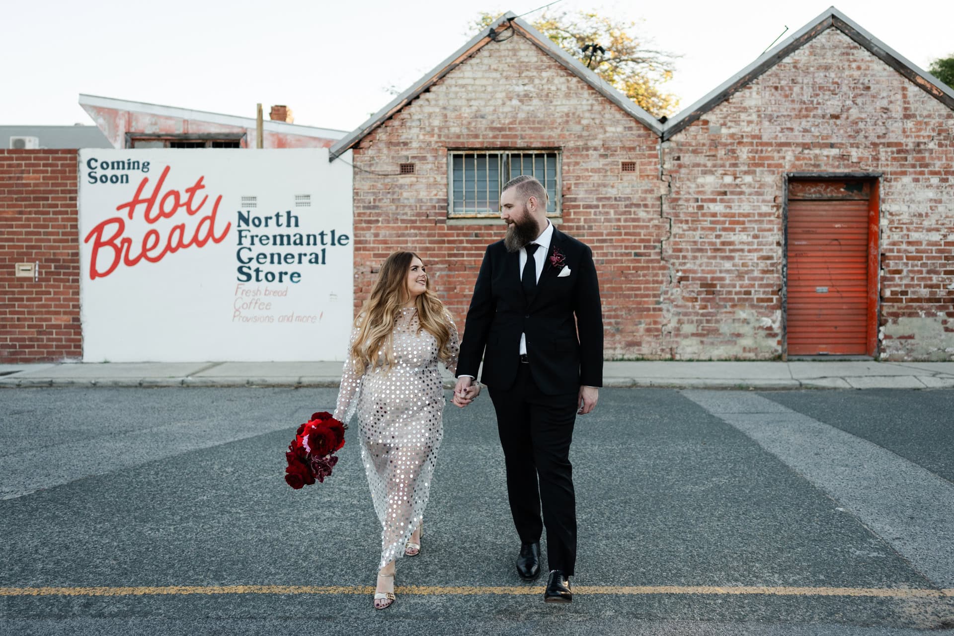 wedding photos perth bride wearing gold dress walking holding hands with groom in black suit